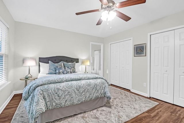 bedroom featuring baseboards, two closets, and wood finished floors