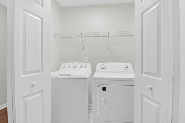 washroom featuring laundry area, dark wood-type flooring, and washer and clothes dryer