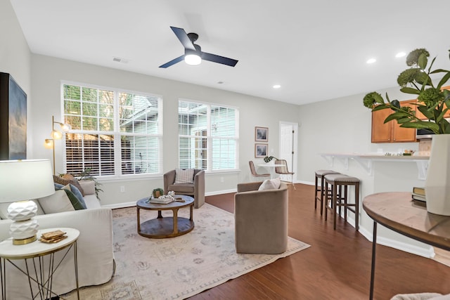 living room featuring baseboards, visible vents, a ceiling fan, wood finished floors, and recessed lighting