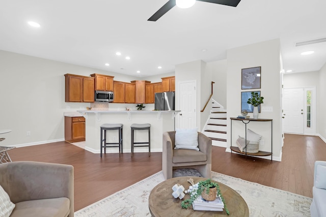 living area with stairs, dark wood-style flooring, baseboards, and recessed lighting