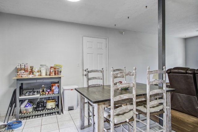 dining area with light tile patterned floors and a textured ceiling