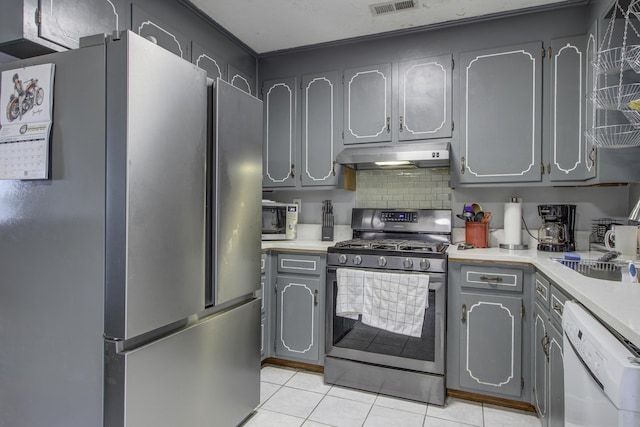 kitchen featuring gray cabinetry, light tile patterned flooring, and stainless steel appliances