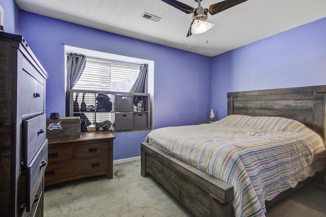 bedroom featuring ceiling fan, light carpet, and a textured ceiling