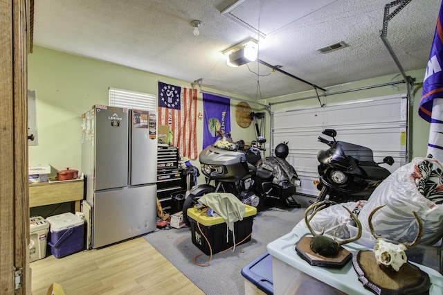 garage featuring stainless steel fridge and a garage door opener