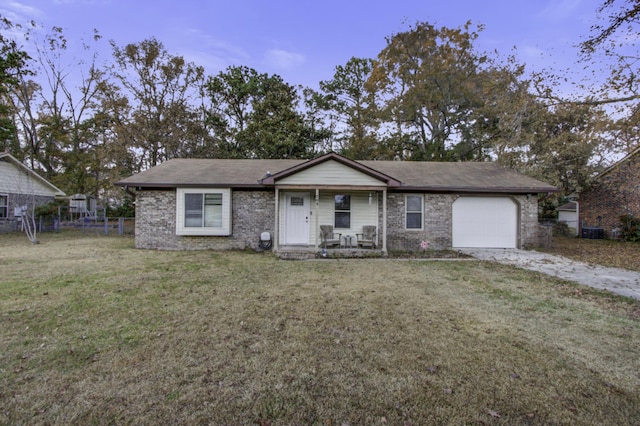 ranch-style home with covered porch, a garage, and a front yard