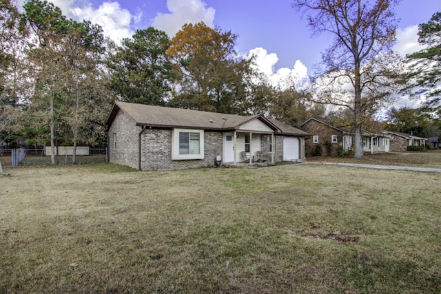 ranch-style house featuring a garage and a front lawn