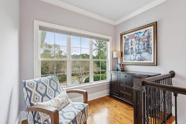 living area featuring light wood-type flooring and crown molding