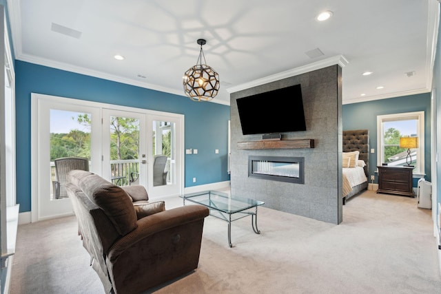 carpeted living room featuring french doors, crown molding, a healthy amount of sunlight, and a tiled fireplace