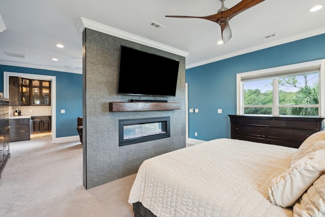 carpeted bedroom featuring ceiling fan, ornamental molding, and a fireplace