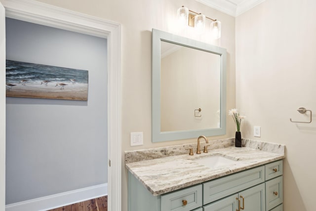 bathroom featuring hardwood / wood-style floors, vanity, and ornamental molding