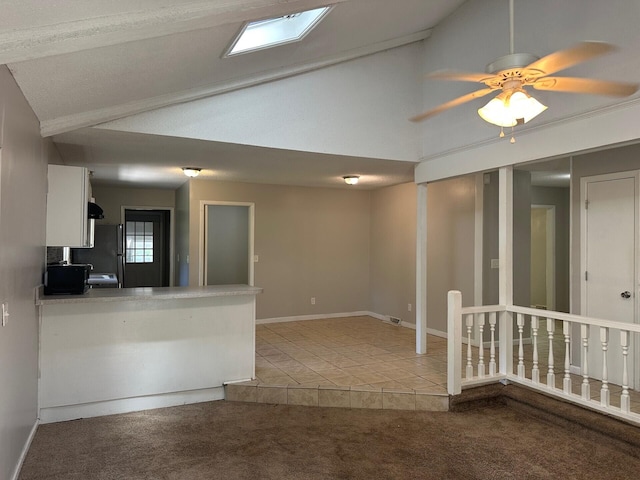 2827 Haverhill Cir N, Charleston, SC 29420 - kitchen with white cabinetry, light tile patterned floors, light colored carpet, high vaulted ceiling, and freestanding refrigerator