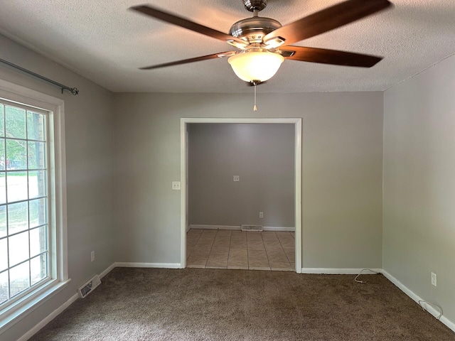 2827 Haverhill Cir N, Charleston, SC 29420 - carpeted empty room featuring plenty of natural light, a textured ceiling, a ceiling fan, and tile patterned flooring