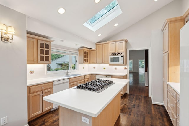 kitchen featuring a kitchen island, sink, light brown cabinets, and a skylight