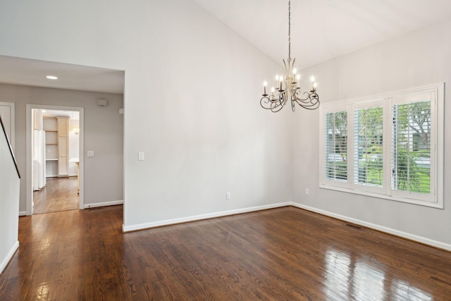 spare room with dark wood-type flooring, high vaulted ceiling, and an inviting chandelier