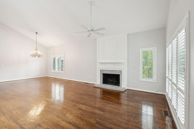 unfurnished living room with a fireplace, dark wood-type flooring, ceiling fan with notable chandelier, and vaulted ceiling