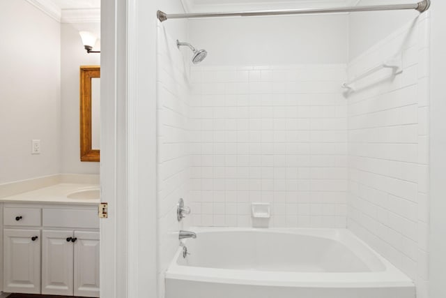 bathroom featuring crown molding, vanity, and tiled shower / bath combo