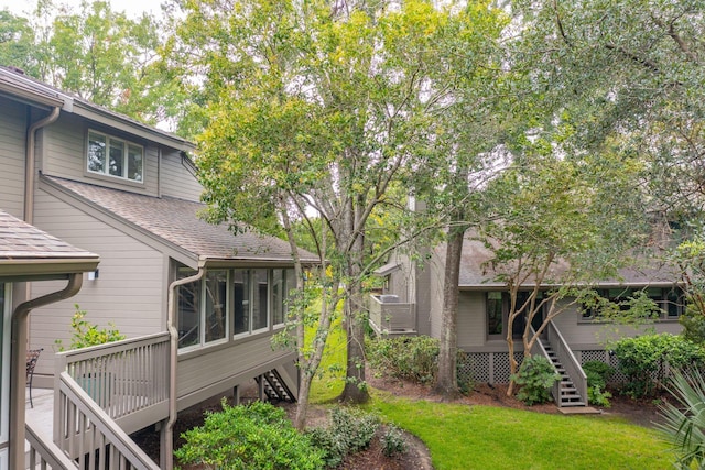 back of property with a sunroom and a deck