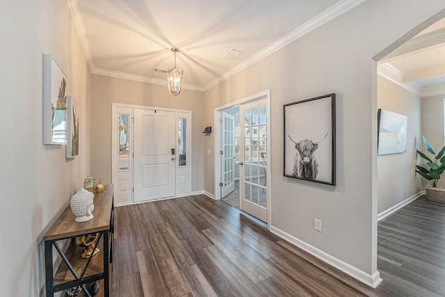 foyer featuring an inviting chandelier, baseboards, ornamental molding, and dark wood finished floors