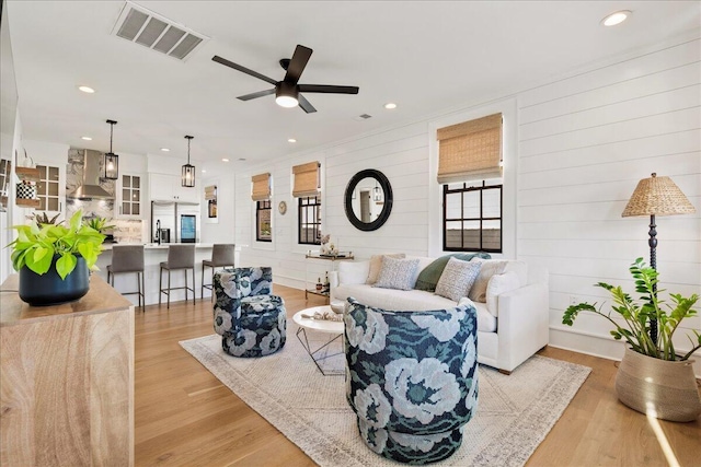 living room with a ceiling fan, recessed lighting, visible vents, and light wood-style floors