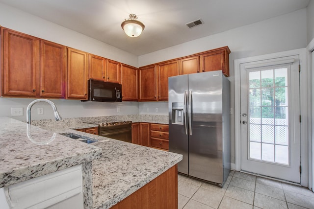 116 Venezia Ct, Ladson, SC 29456 - kitchen featuring stainless steel appliances, a sink, brown cabinetry, light stone countertops, and light tile patterned flooring