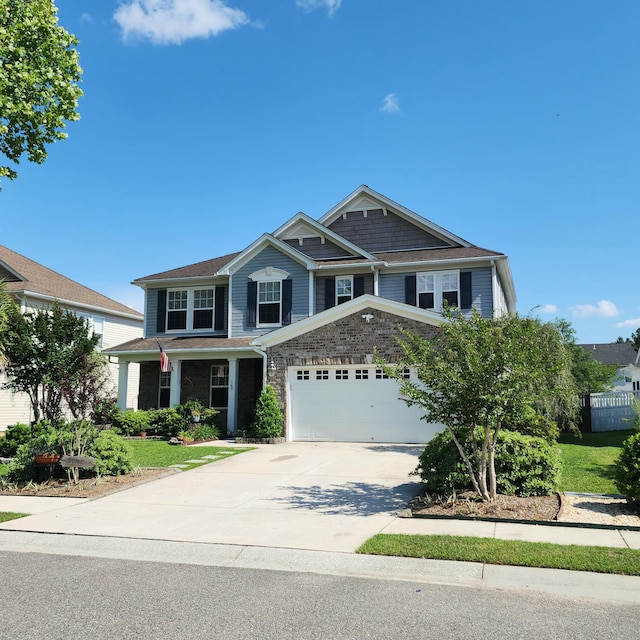 view of front facade with driveway, fence, and an attached garage