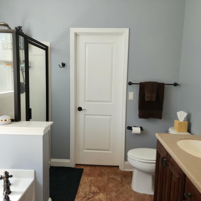 full bath with baseboards, a stall shower, vanity, and toilet
