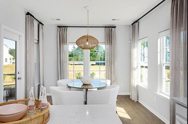 dining area with plenty of natural light and hardwood / wood-style flooring