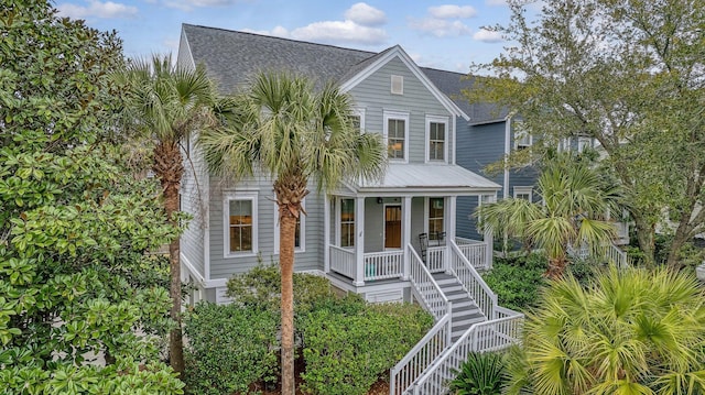 view of front of house with stairway, a shingled roof, and covered porch