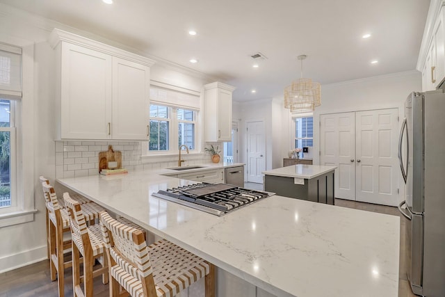 kitchen featuring appliances with stainless steel finishes, decorative backsplash, ornamental molding, and dark wood-type flooring
