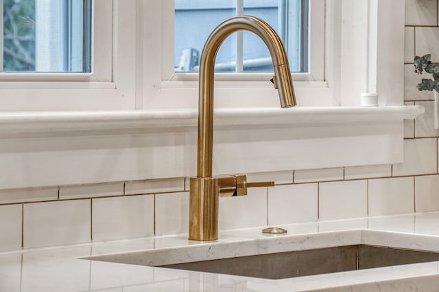 interior details featuring backsplash and a sink