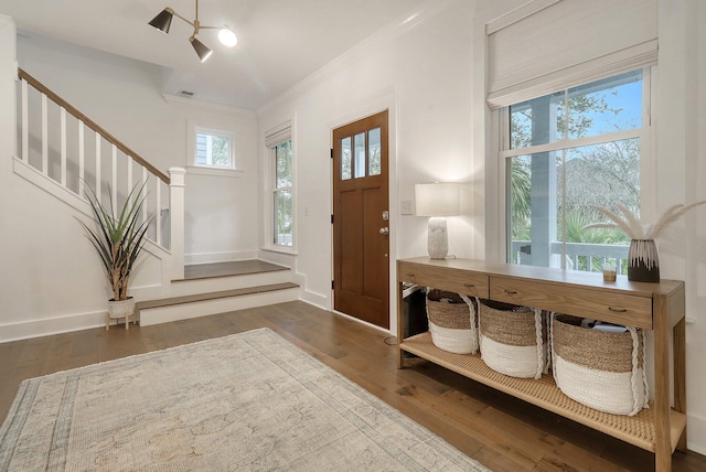 entrance foyer with stairway, crown molding, hardwood / wood-style flooring, and baseboards
