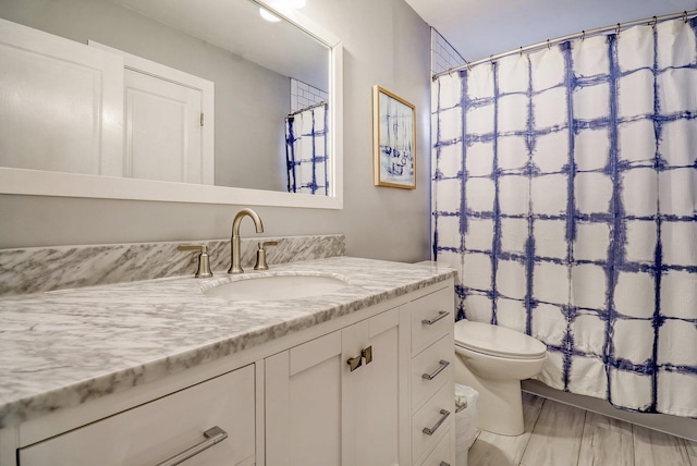 bathroom with toilet, vanity, and curtained shower