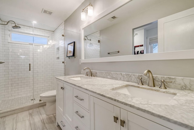 full bath with a shower stall, toilet, visible vents, and a sink