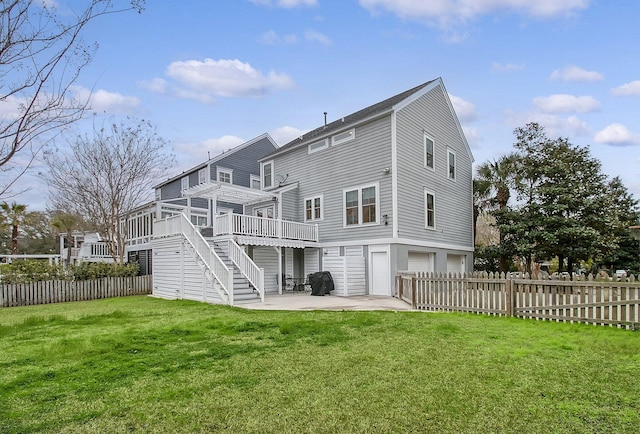 rear view of house featuring an attached garage, fence, a wooden deck, and stairs