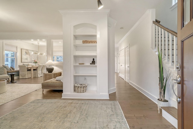 entrance foyer featuring a healthy amount of sunlight, stairway, wood finished floors, and ornamental molding