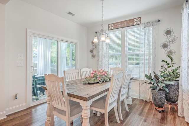 dining room featuring wood finished floors, baseboards, and a chandelier