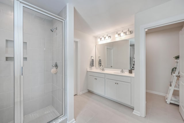 full bath featuring a stall shower, tile patterned floors, baseboards, and vanity