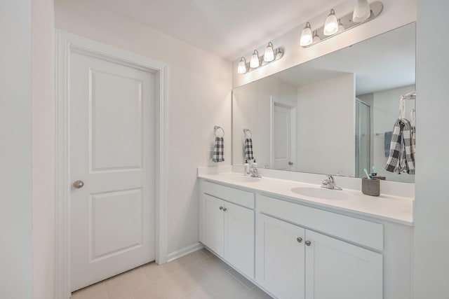 full bathroom with tile patterned floors, a shower stall, double vanity, and baseboards