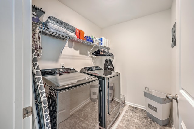clothes washing area with washer and clothes dryer, wood finished floors, and baseboards
