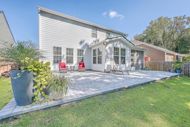 rear view of property with a sunroom and a patio area