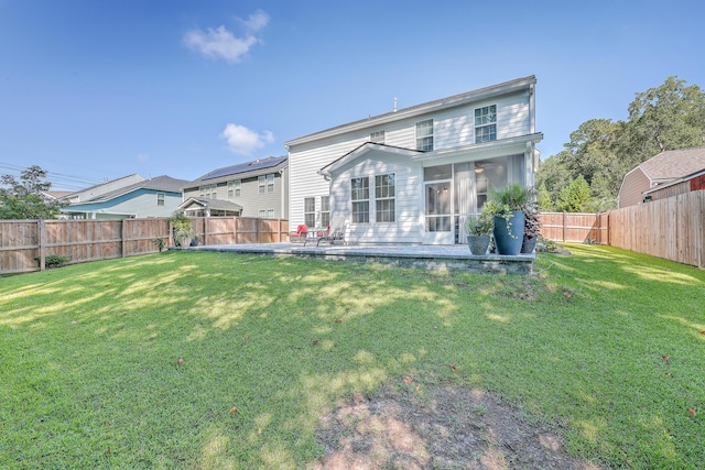 rear view of house featuring a sunroom and a patio