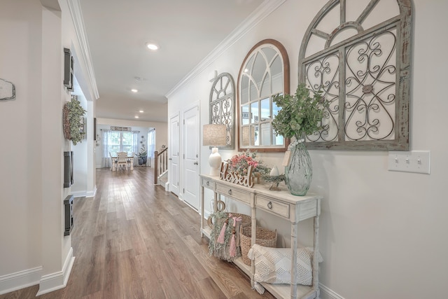 hallway featuring wood finished floors, recessed lighting, ornamental molding, and baseboards