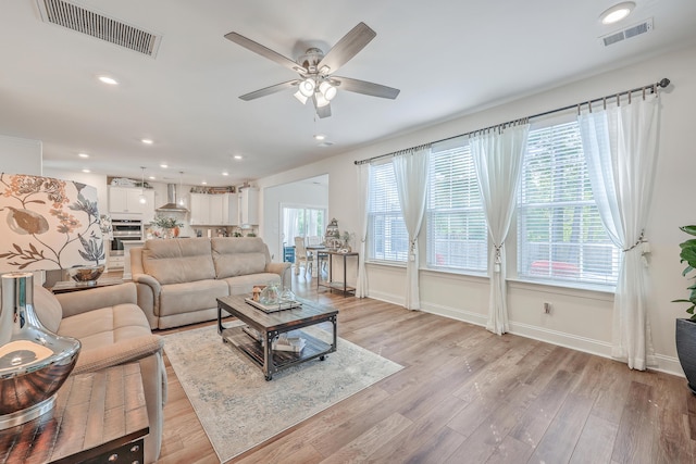 living area with a ceiling fan, light wood-style floors, baseboards, and recessed lighting