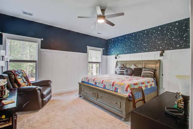 3025 Rampart Rd, Summerville, SC 29483 - carpeted bedroom with wainscoting, a decorative wall, multiple windows, and a ceiling fan