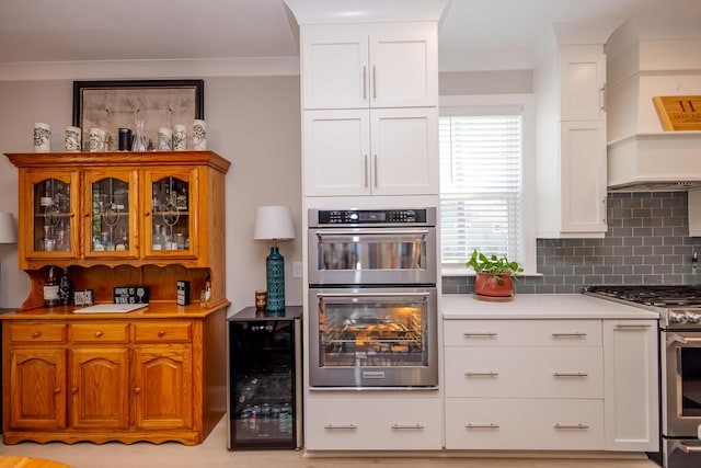 3025 Rampart Rd, Summerville, SC 29483 - kitchen with beverage cooler, stainless steel appliances, backsplash, white cabinetry, and glass insert cabinets