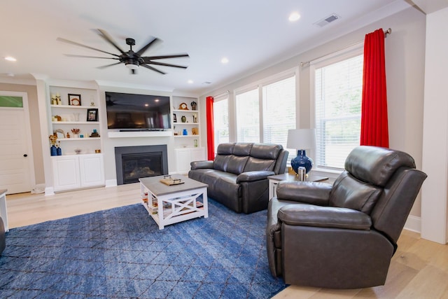 3025 Rampart Rd, Summerville, SC 29483 - living area with light wood-type flooring, a glass covered fireplace, ceiling fan, recessed lighting, and built in shelves