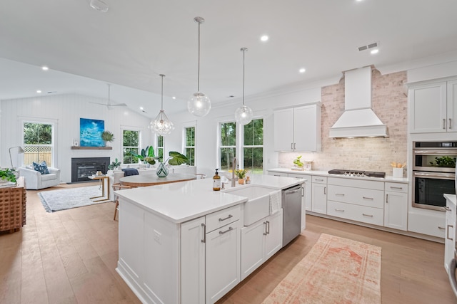 5710 Barbary Coast Rd, Hollywood, SC 29449 - kitchen with stainless steel appliances, custom range hood, vaulted ceiling, a glass covered fireplace, and light countertops