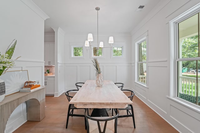 5710 Barbary Coast Rd, Hollywood, SC 29449 - dining space featuring a decorative wall, light wood-type flooring, a chandelier, and ornamental molding