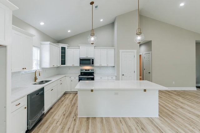 kitchen featuring light countertops, stainless steel appliances, light wood-style flooring, and a center island