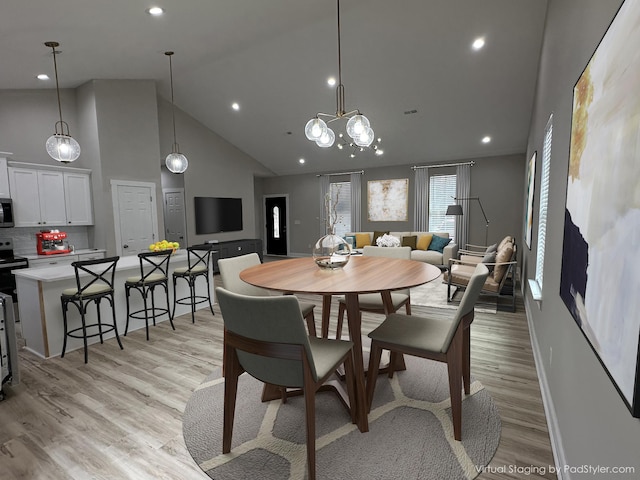 dining room with light wood-type flooring, recessed lighting, baseboards, and high vaulted ceiling